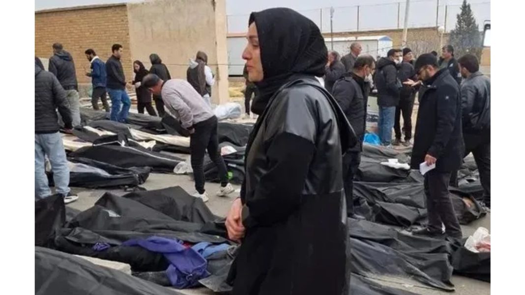 ইরানের একটি ফরেনসিক সেন্টারে রাখা মৃতদেহের পাশে দাঁড়িয়ে আছেন একজন নারী। ছবি: সংগৃহীত