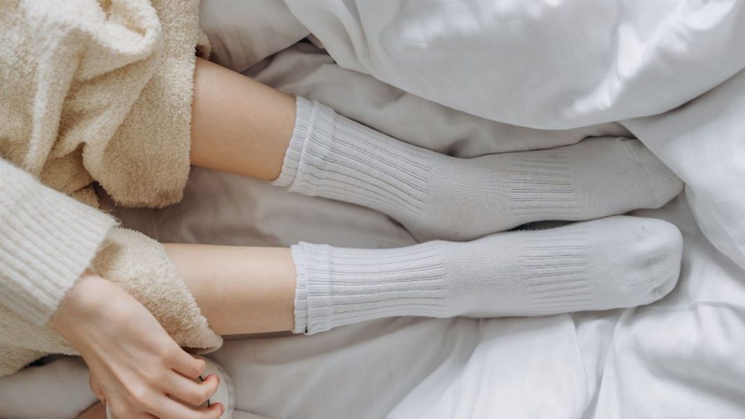 রাতে ঘুমানোর আগে হাত, পায়ে মোজা পরার অভ্যাসে সুফলের পাশাপাশি রয়েছে ঝুঁকিও। ছবি: সংগৃহীত